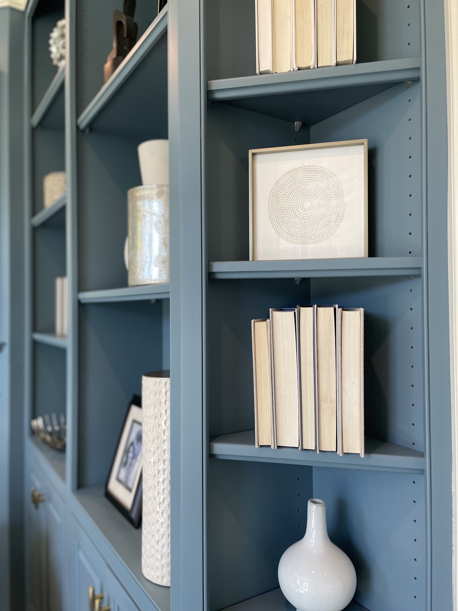 Blue Bookshelves with white decorative accessories and white books